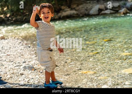 A child playing in the turquoise river of Valbona Valley, Theth National Park, Albanian Alps, Albania Stock Photo