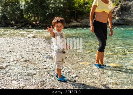 A child playing in the turquoise river of Valbona Valley, Theth National Park, Albanian Alps, Albania Stock Photo