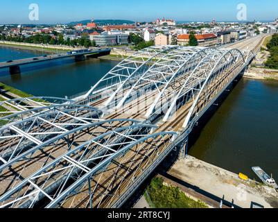 New triple tied-arc railroad bridge with four tracks over Vistula river in Krakow, Poland. Another bridge with cars and tram. Old town with Wawel cast Stock Photo