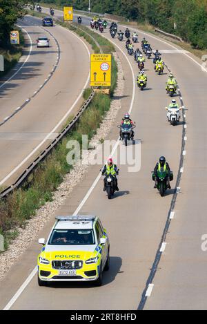 Motorcycle convoy with police escort on the A12 at Galleywood near Chelmsford, Essex, UK. Charity motorbike run for Essex & Herts Air Ambulance Trust Stock Photo