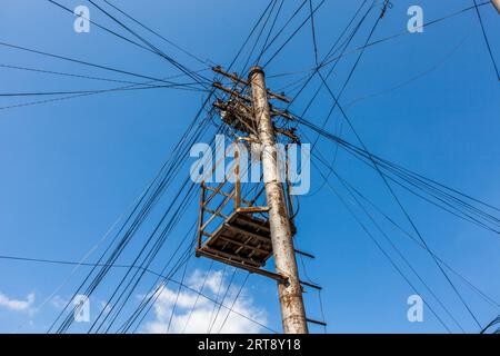 Electricity pylon in the Chugureti district of Tbilisi: a wooden work platform is attached to the pylon, with numerous utility cables radiating out in all directions like the points of a star. The dense network of cables, which has grown over decades, is a ubiquitous feature of the streetscape in the older residential districts of the Georgian capital. Chugureti, Tbilisi, Georgia, Europe Stock Photo