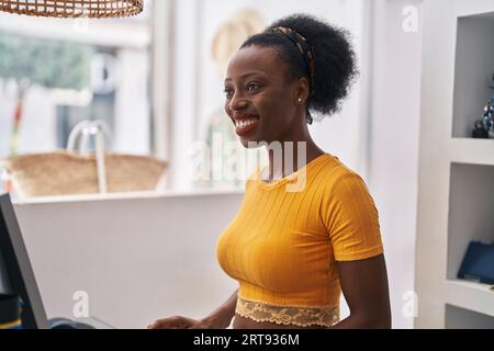 African american woman shop assistant using computer working at clothing store Stock Photo