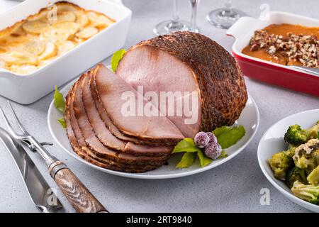 Honey glazed spiral sliced ham with side dishes for a celebration dinner on Thanksgiving or Christmas Stock Photo