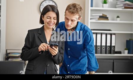 Two business workers using smartphone working at the office Stock Photo