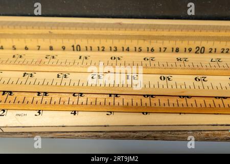 Group of wooden yard sticks and meter sticks with black background. Stock Photo