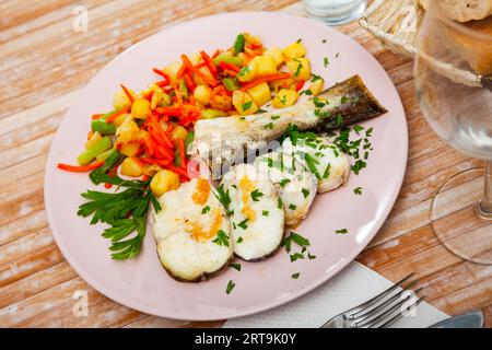 Oven baked hake with vegetable garnish Stock Photo
