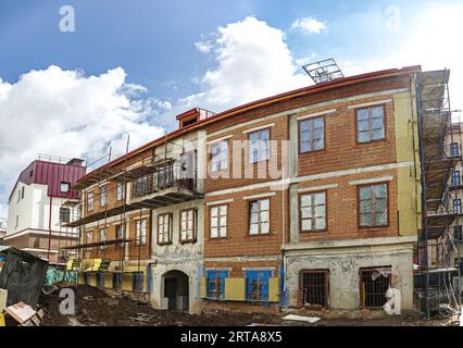 scaffolding around a building renovating facade. house reconstruction. panoramic view. Stock Photo