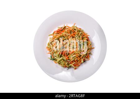 Fresh salad of sliced thin strips of carrot and zucchini on a concrete background. Vegetarian cuisine Stock Photo