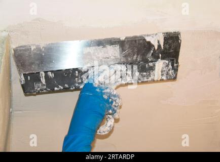 Female plasterer painter repairing a ceiling indoor Stock Photo