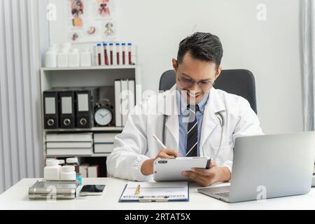 Doctor Man's professional work using a digital tablet at his hospital research medicine digital care healthcare concept Stock Photo