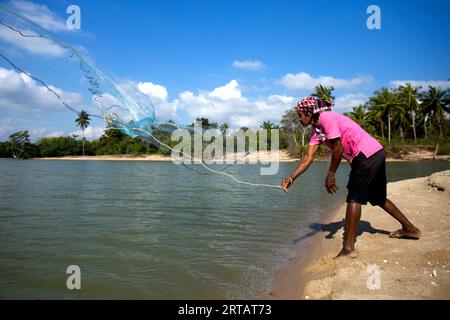 Man throwing a fishing net from a small boat on the Gulf Coast