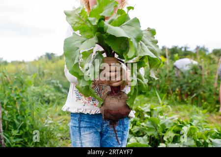 Healthy lifestyle concept: Happy child with garden-fresh beets in hand Stock Photo