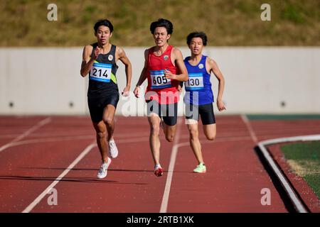 Japanese athletes running on track Stock Photo