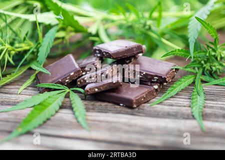 Marijuana leaf and chocolate on brown wooden background Stock Photo