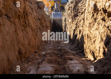 Excavator digging a trench ditch for a small house foundation Stock Photo