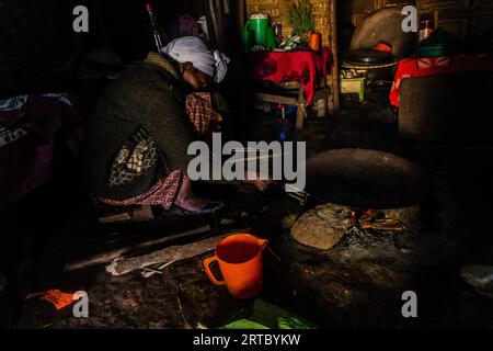 DORZE, ETHIOPIA - JANUARY 30, 2020: Dorze woman is preparing kocho bread made of enset in a traditional hut woven out of bamboo, Ethiopia Stock Photo