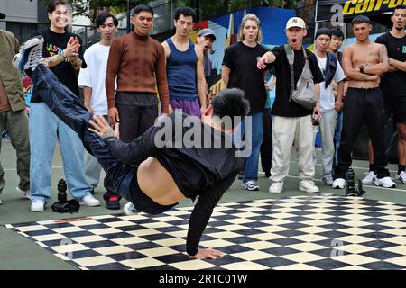 One-Handed Air Flare Breakdancing battle, impressive Hip Hop competition & an audience of dancers on the basketball courts of  Woolloomooloo, Sydney Stock Photo