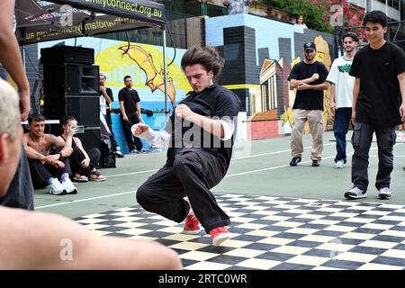 A Bboy makes a flying break power move - Street Breakdancing step performance, competition and battles - dance action in Woolloomooloo, Sydney Stock Photo