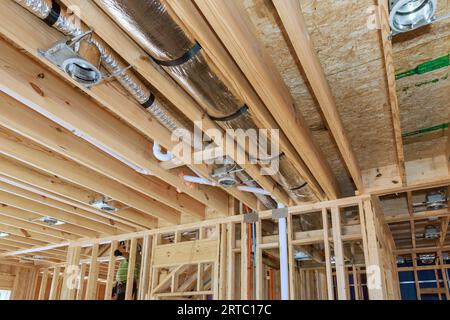 Installing central HVAC system puts spotlight on wooden beamed ceiling in new home. Stock Photo