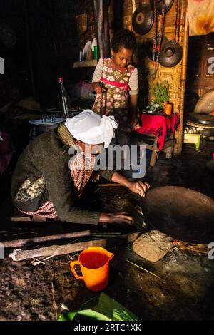 DORZE, ETHIOPIA - JANUARY 30, 2020: Dorze woman is preparing kocho bread made of enset in a traditional hut woven out of bamboo, Ethiopia Stock Photo