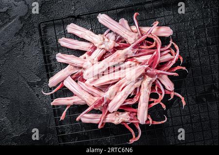 Raw Duck Tongue ready for cooking. Black background. Top view. Stock Photo