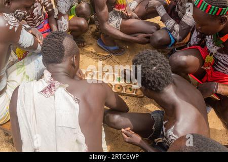 KORCHO, ETHIOPIA - FEBRUARY 4, 2020: Men of Karo tribe playing mancala (bao) game in Korcho village, Ethiopia Stock Photo