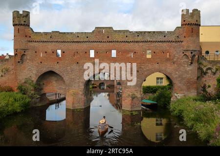 The Berkelpoort, a historical water gate in the city of Zutphen, Gelderland, Netherlands, with a couple kayaking in the foreground Stock Photo