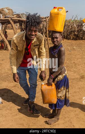 OMORATE, ETHIOPIA - FEBRUARY 5, 2020: City-dweller visiting Daasanach tribe in their village near Omorate, Ethiopia Stock Photo