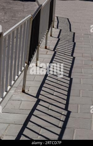 Handrail by road. Pedestrian barrier. Fence along road. Fencing details. Stock Photo