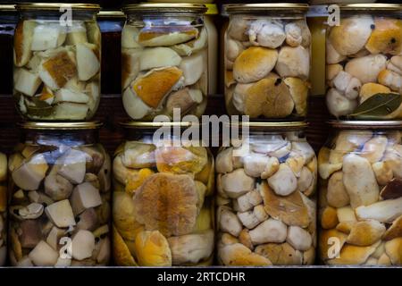 The preserve mushrooms. Delicious marinated white mushrooms in the glass jars. Homemade preservation in autumn. Stock Photo