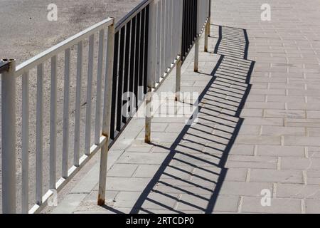 Handrail by road. Pedestrian barrier. Fence along road. Fencing details. Stock Photo