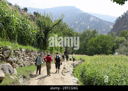 Travellers walking in the Kalash Valley Stock Photo