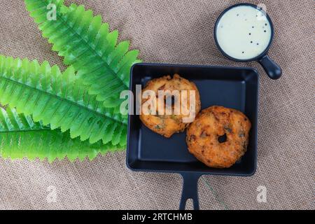 Indian traditional snacks medhu vadai also called ulunda vadai. Famous Tamilnadu snack called medhu vada in a plate, served with coconut chutney. Vada. Stock Photo