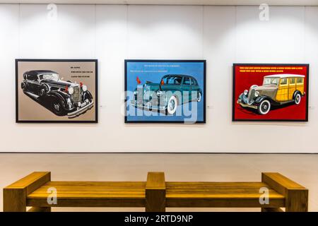 Three paintings of classic cars bear English quotations attributed to Hitler, Stalin and Al Capone in the Georgian Museum of Fine Arts (Georgian: ქართული სახვითი ხელოვნების მუზეუმი) at 7 Rustaveli Avenue in Tbilisi, Georgia. On the left, a black Mercedes limousine with red pennants stands against a beige background, beside the sentence attributed to Hitler: "He alone who owns the youth gains the future." In the middle, a dark-green limousine with small red flags (possibly a ZIS-110) is set against a blue background. Above it is the sentence attributed to Stalin: "The death of one man is a trag Stock Photo