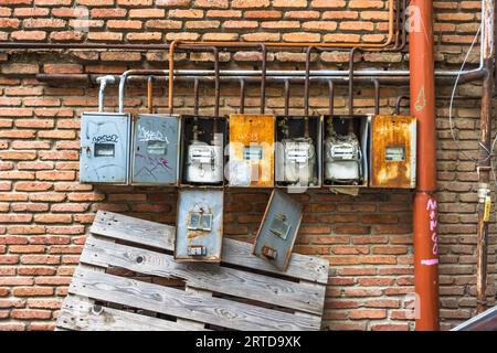 Gas meters on a brick wall in a courtyard in Tbilisi: five rusty meter boxes – some left open, others covered in graffiti – and a tangle of rusty orange pipes bear witness to the often makeshift infrastructure in the backyards of the Georgian capital. A wooden pallet is leaning against the wall beneath them. Betlemi Street, Betlemi, Kala, Ortachala, Krtsanisi District, Tbilisi, 0108, Georgia Stock Photo