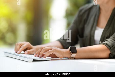 Unrecognizable woman typing on wireless computer keyboard Stock Photo