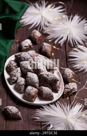 Italian Christmas cookies Castagnelle with almonds, cocoa and egg whites on a wooden background. Gluten free cookies. Stock Photo