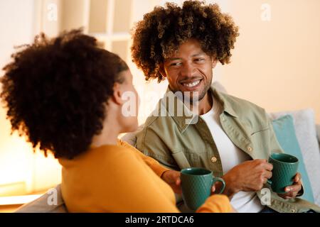 African Spouses Bonding Over Coffee and Flirty Talks At Home Stock Photo