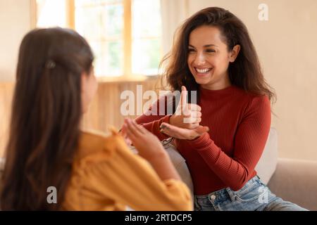 Arabic deaf mute mother and daughter using sign language indoor Stock Photo