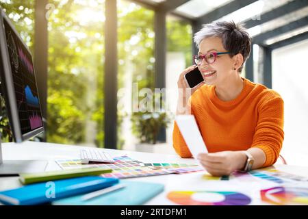 Middle aged woman designer working at coworking space Stock Photo