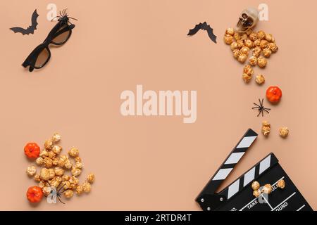 Composition with tasty caramel popcorn, clapperboard, 3D glasses and Halloween decor on beige background Stock Photo