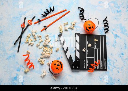 Movie clapperboard, popcorn and Halloween decor on blue grunge background Stock Photo