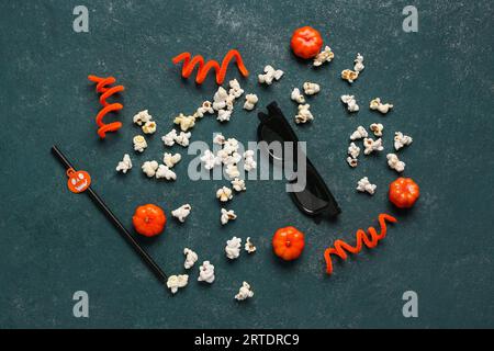 Popcorn, movie clapperboard and Halloween decor on green grunge background Stock Photo