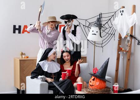 Group of friends in costumes at Halloween party Stock Photo