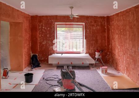 Renovation Of A Flat With Red Primer Paint On The Walls Stock Photo