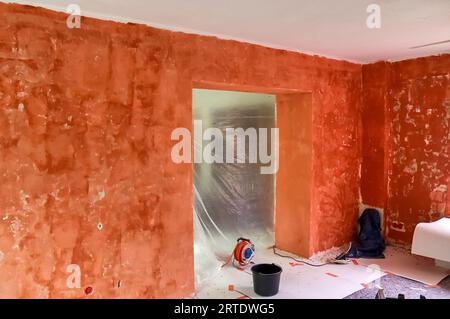 Renovation Of A Flat With Red Primer Paint On The Walls Stock Photo