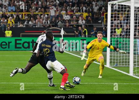 Dortmund, Germany. 12th Sep, 2023. Soccer: Internationals, Germany - France, Signal Iduna Park. Germany's Antonio Rüdiger (l) in a duel with France's Randal Kolo Muani in front of the goal of Germany's goalkeeper Marc-Andre ter Stegen (r) IMPORTANT NOTE: In accordance with the requirements of the DFL Deutsche Fußball Liga and the DFB Deutscher Fußball-Bund, it is prohibited to use or have used photographs taken in the stadium and/or of the match in the form of sequence pictures and/or video-like photo series. Credit: Bernd Thissen/dpa/Alamy Live News Stock Photo