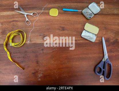 Different Sewing Accessoires On A Brown Wooden Background. Sewing Concept. Stock Photo
