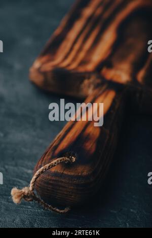 Handmade Cutting Board with Handle on Dark Concrete Surface Stock Photo