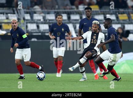 Dortmund, Germany. 12th Sep, 2023. Soccer: International match, Germany - France, Signal Iduna Park. Germany's Serge Gnabry (2nd from right) passes the ball next to France's Randal Kolo Muani (right). Credit: Rolf Vennenbernd/dpa - IMPORTANT NOTE: In accordance with the requirements of the DFL Deutsche Fußball Liga and the DFB Deutscher Fußball-Bund, it is prohibited to use or have used photographs taken in the stadium and/or of the match in the form of sequence pictures and/or video-like photo series./dpa/Alamy Live News Stock Photo